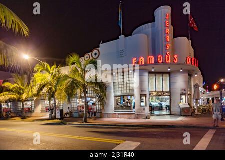 Miami, USA - 2. August 2010: Nachtansicht am Ocean Drive in Miami Beach, Florida. Das Art déco-Gebäude Jerrys Famous Deli ist ein Fastfood-Restaurant Stockfoto