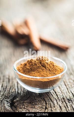 Trockenes Zimtpulver in einer Schüssel auf einem Holztisch. Zimt-Gewürz. Stockfoto