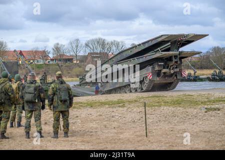 02. April 2022, Sachsen-Anhalt, Hohengöhren: Ein "Iguana"-Brückentank rollt auf eine schwimmende Brücke an der Elbe. Das Manöver fand im Rahmen der Übung „Wettin Sword“ statt, die mehrere Tage dauert und unter anderem im Kampftrainingszentrum der Armee stattfindet und für die die Fahrzeuge unterwegs sind. Foto: Klaus-Dietmar Gabbert/dpa Stockfoto