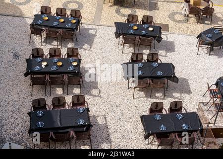 Badajoz, Spanien - 27. März 2022: Blick aus der Höhe auf viele leere Restauranttische mit schwarzen Tischdecken und Platz auf einem offenen Platz Stockfoto