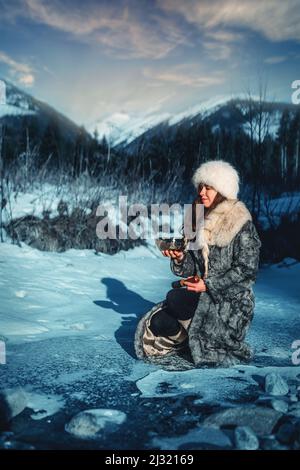 Schöne schamanische Mädchen spielen auf tibetische Schüssel in der Natur. Stockfoto