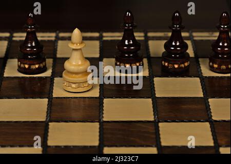Weißer Bauer vor schwarzen Bauern auf einem Schachbrett Stockfoto