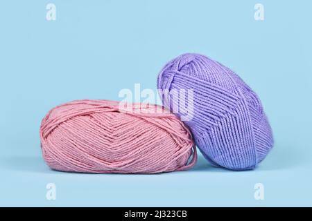 Rosa und lila Wollkugeln auf blauem Hintergrund Stockfoto