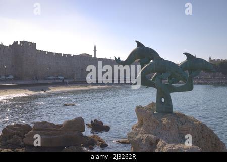 Delfinstatue am Mandraki Hafen und Hafen in der Nähe der Mauern der Altstadt von Rhodos Stockfoto