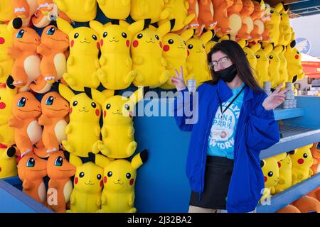 Eine Teenager aus Brooklyn beginnt ihren Sommerjob, indem sie an den Frühlingswochenenden an einem Geschicklichsspiel im Luna Park arbeitet. In Coney Island, Brooklyn, New York City. Stockfoto