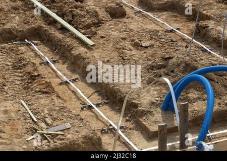 Bau des Gebäudes. Bau von Mietshaus. Ausgehobener Graben im Boden für das Fundament Stockfoto