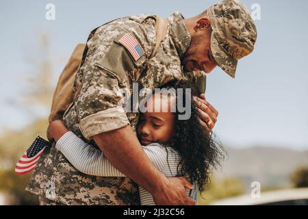 Emotionaler Soldat, der seine Auf Wiedersehen seiner Tochter sagte, bevor er in den Krieg ging. Patriotischer Militärangehöriger umarmt sein Kind, bevor er zum Dienst an seinem Coun geht Stockfoto