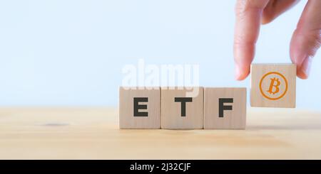 Exchange Traded Fund (ETF) und Bitcoin-Kryptowährungskonzept. Einstieg in das Konzept des digitalen Geldfonds. Investor hält den Holzwürfel mit Bitcoin i Stockfoto