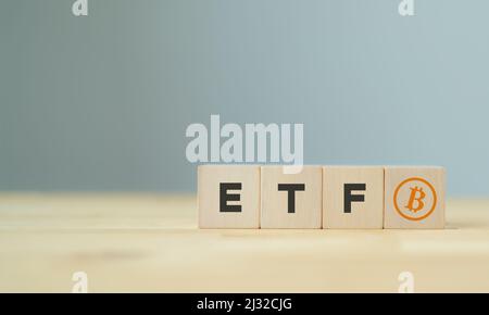 Exchange Traded Fund (ETF) und Bitcoin-Kryptowährungskonzept. Einstieg in das Konzept des digitalen Geldfonds. Der Holzwürfel mit Bitcoin-Symbol steht wi Stockfoto