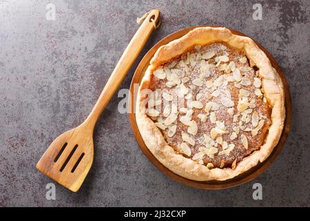 Bakewell Pudding ist eine süße Torte, ein knackiger Konditoreikasten, der mit süßem Mandelschwamm über Himbeermarmelade in der Nähe auf dem Tisch gefüllt ist. Horizontale Ansicht von oben Stockfoto