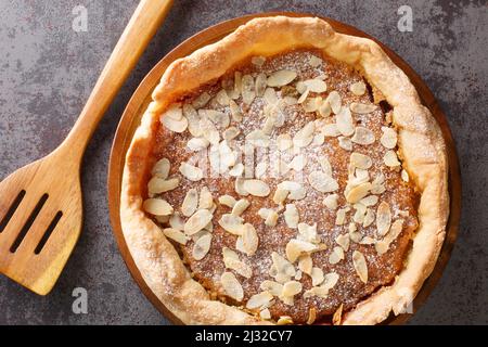 Englisches Dessert Bakewell Pudding Kuchen mit Himbeermarmelade und Füllung aus Ei und Mandelpaste aus nächster Nähe auf dem Tisch. Horizontale Ansicht von oben Stockfoto