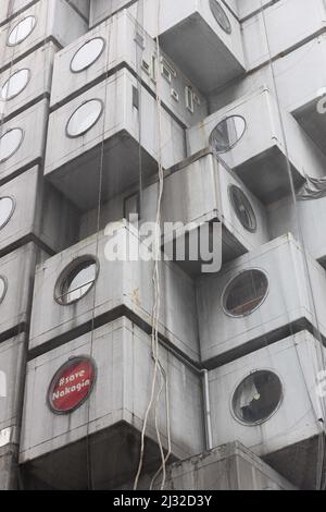 Ein Schild „Save Nakagin“, das in einem Fenster des Nakagin Capsule Tower Building, das von Kisho Kurokawa entworfen wurde (Beispiel des japanischen Stoffwechsels aus den Jahren 1970-1972), zu sehen ist, soll am 12. April 2022 abgerissen werden. Am 15. April 2007 stimmte eine Mehrheit der Kapselbesitzer für den Abriss des Turms, da er sich verschlechterte und Angst vor Asbest hatte, der im Bauprozess verwendet wurde. Es hat viele Versuche gegeben, das Gebäude zu retten, weil es aufgrund seines Designs, seiner Struktur und seiner Philosophie als einzigartig angesehen wird. (Foto von Stanislav Kogiku/SOPA Images/Sipa USA) Stockfoto
