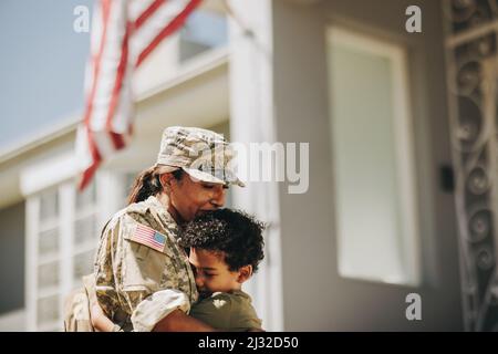 Mutter und Sohn vereinigen sich nach militärischem Einsatz wieder. Emotionale Mutter umarmte ihren Sohn, nachdem sie von der Armee nach Hause zurückgekehrt war. Patriotische Soldatinnen recei Stockfoto