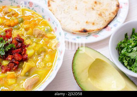 Teller mit Kuttelsuppe, genannt Mondongo, traditionelles Essen aus Kolumbien, Südamerika, auf hellem Holz. Stockfoto