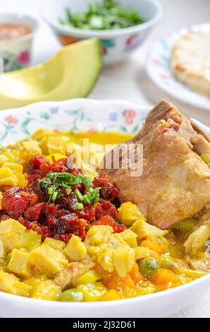 Teller Suppe mit Kutteln und Backbone Schweinefleisch, genannt Mondongo, traditionelle Lebensmittel aus Kolumbien, Südamerika, auf hellem Holz. Callos, mondongo, guatita, Tri Stockfoto