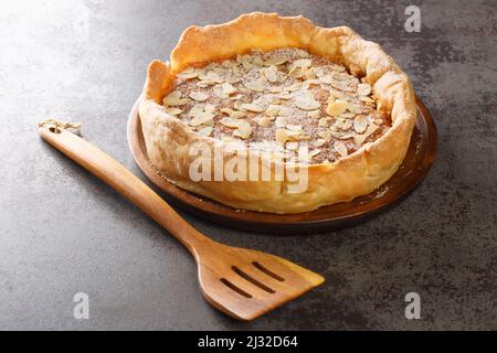 Bakewell Pudding ist eine süße Torte, ein knackiger Konditoreikasten, der mit süßem Mandelschwamm über Himbeermarmelade in der Nähe auf dem Tisch gefüllt ist. Horizontal Stockfoto