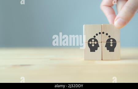 Wissen und Ideen teilen zwischen zwei Menschen Kopf Ikone auf Holzwürfel. Wissenstransfer, Innovation, Brainstorming-Konzept. Geschäftsstrategie Stockfoto