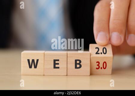 Web-Entwicklung, die nächste Generation des Internets, Web 3,0 Konzept. Futuristische Technologie für das menschliche Leben. Hand dreht Holzwürfel WEB 2,0 Stockfoto