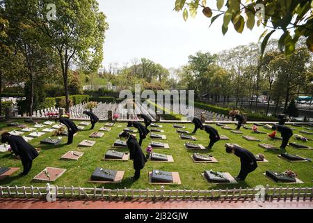 Peking, die chinesische Provinz Jiangsu. 4. April 2022. Mitarbeiter zollen dem Verstorbenen im Namen der Hinterbliebenen auf einem Friedhof in Nanjing, der ostchinesischen Provinz Jiangsu, Tribut, 4. April 2022. Der Tag, an dem das Grab hinwegfegen wird, wird auch Qingming-Fest genannt und ist ein Tag für die Chinesen, an dem sie die Gräber ihrer Vorfahren und verstorbenen Angehörigen besuchen können. Zum Teil aufgrund des jüngsten Wiederauflebens von COVID-19 wurden verschiedene kohlenstoffarme Mittel zur Anerkennung verstorbener Verwandter, wie Online-Aktivitäten und Blumenpräsentationen, gefördert. Quelle: Ji Chunpeng/Xinhua/Alamy Live News Stockfoto