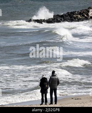 05. April 2022, Mecklenburg-Vorpommern, Kühlungsborn: Wanderer sind auf der aufwühlenden Ostsee in Sonne und Wind unterwegs. Foto: Bernd Wüstneck/dpa Stockfoto