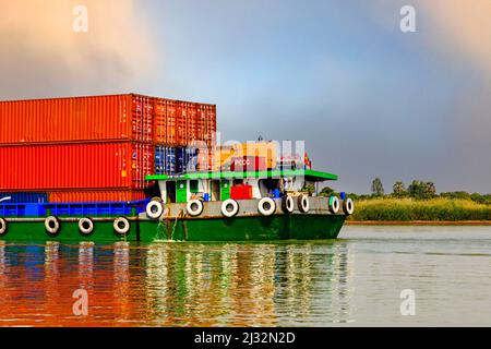 Teil eines Lastkahnes, der rote Container für die Lieferung von Kambodscha nach Vietnam transportiert. Zeigt die Heck-Hafenseite des Bootes. Stockfoto