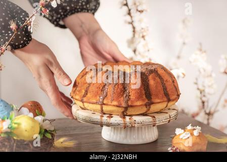 Schokoladen-Vanillekuchen mit osterdekorationen auf einem Holztisch, Stillleben-Fotografie Stockfoto