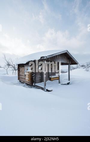 Kleine Hütte umgeben von Schnee in Finnisch-Lappland Stockfoto