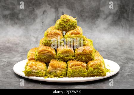 Pistazien-Baklava-Dessert auf dunklem Hintergrund. Traditionelle türkische Küche Delikatessen. Nahaufnahme Pistachio Baklava. Lokaler Name kuru Baklava Stockfoto