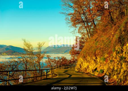 Bergkette über Wolkenlandschaft und Bergstraße mit Sonnenlicht und klarem Himmel in Lugano, Tessin in der Schweiz. Stockfoto