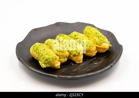 Pistazie eclair Kuchen isoliert auf weißem Hintergrund. Köstlichkeiten der Weltküche. Nahaufnahme Stockfoto