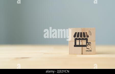 Online-Shopping und Online-Marketing-Konzept. Die Holzwürfel mit Shop- und Online-Kauf-Icons auf grauem Hintergrund und Kopierfläche. Marketing und Stockfoto