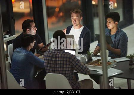 Die besten Ideen auf den Tisch bringen. Aufnahme von Mitarbeitern, die nachts in einem Büro arbeiten. Stockfoto