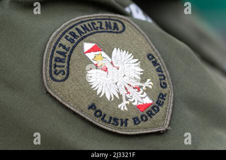 Ein Wappen der Polen, das auf der Uniform einer polnischen Grenzwache am Grenzübergang in Grzechotki zu sehen ist. Russland marschierte am 24. Februar 2022 in die Ukraine ein und löste damit den größten militärischen Angriff in Europa seit dem Zweiten Weltkrieg aus Bis zu 10 Millionen Ukrainer sind aus ihren Häusern geflohen, entweder aus dem Land oder in sicherere Gebiete innerhalb der Ukraine. Es wird angenommen, dass etwa 3 Millionen Flüchtlinge die Grenzen in Nachbarländer überschritten haben. Stockfoto