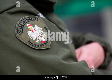 Ein Wappen der Polen, das auf der Uniform einer polnischen Grenzwache am Grenzübergang in Grzechotki zu sehen ist. Russland marschierte am 24. Februar 2022 in die Ukraine ein und löste damit den größten militärischen Angriff in Europa seit dem Zweiten Weltkrieg aus Bis zu 10 Millionen Ukrainer sind aus ihren Häusern geflohen, entweder aus dem Land oder in sicherere Gebiete innerhalb der Ukraine. Es wird angenommen, dass etwa 3 Millionen Flüchtlinge die Grenzen in Nachbarländer überschritten haben. Stockfoto