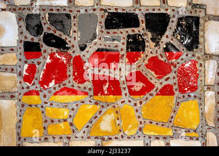 Nationalflagge von Deutschland auf Steinmauer Hintergrund. Flag Banner auf Stein Textur Hintergrund. Stockfoto