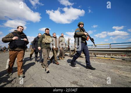 Bucha, Ukraine. 04. April 2022. Der ukrainische Präsident Wolodymyr Zelensky (C) geht auf einer Straße entlang, die ich am Montag, den 4. April 2022, von der ukrainischen Armee in Bucha in der Nähe von Kiew, Ukraine, wieder erobert habe. Der ukrainische Präsident Wolodymyr Zelenski sagte am 3. April 2022, die russische Führung sei für zivile Tötungen in Bucha, außerhalb von Kiew, verantwortlich, wo nach der Rückeroberung der Stadt durch die ukrainische Armee Leichen auf der Straße gefunden wurden. Foto: Ukrainian Presidential Office/ Kredit: UPI/Alamy Live News Stockfoto