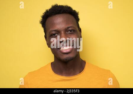 Lächelnder afrikanischer Mann, der die Kamera anschaut. Porträt eines schwarzen selbstbewussten Mannes. Erfolgreicher Unternehmer, der sich zufrieden fühlt. Stockfoto