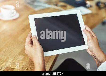 Alle richtigen Werkzeuge stehen zu Ihrer Verfügung. Nahaufnahme einer Person, die ein digitales Tablet in einem modernen Büro hält. Stockfoto