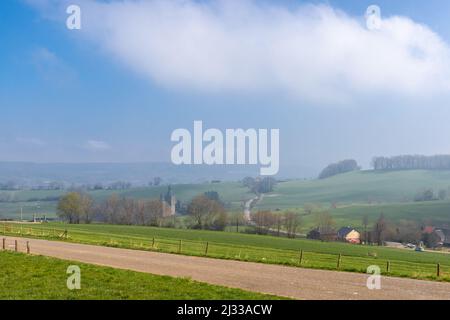 Eine neblige Frühlingslandschaft mit Blick über die Wiesen und Hügellandschaften an der Grenze zwischen den Niederlanden und Belgien. Stockfoto