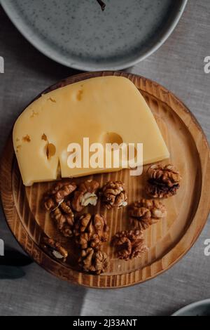 Hartnusskäse mit Nüssen auf einem Teller mit Snacks. Rustikaler Stil. Freier Speicherplatz für Kopien. Stockfoto