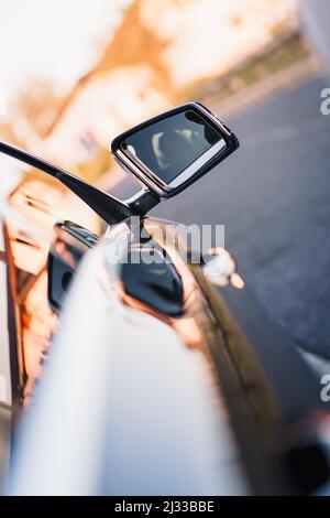 Ein Blick auf die Silhouette einer Frau vom Seitenspiegel eines Autos aus Stockfoto