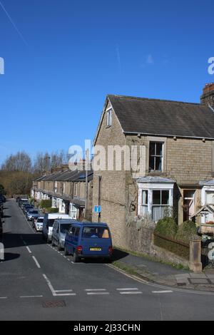 Brook Street an der Kreuzung mit der Aldcliffe Road, Lancaster, Lancashire, England, zeigt geparkte Autos vor einer Reihe von Steinhäusern mit Terrassen, März 2022. Stockfoto