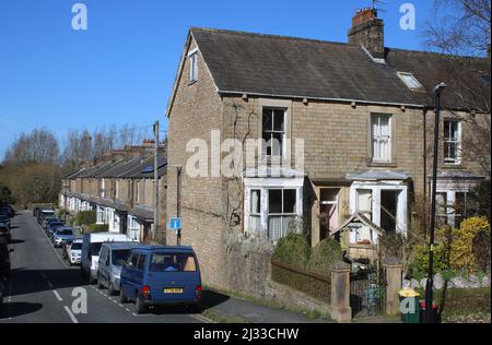 Brook Street an der Kreuzung mit der Aldcliffe Road, Lancaster, Lancashire, England, zeigt geparkte Autos vor einer Reihe von Steinhäusern mit Terrassen, März 2022. Stockfoto