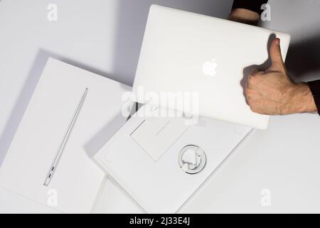 Saratov, Russland - 26. Februar 2022: Zeigen ausgezeichnete Qualität von Macbook Air 13 Zoll mit M1 Prozessor, Verpackung mit Ladevorgang, weißer Hintergrund Stockfoto