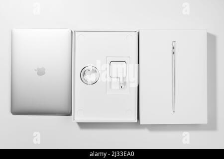 Saratov, Russland - 26. Februar 2022: Sequenzielle Anordnung von Macbook Air 13 Zoll M1 Prozessor und Verpackung mit Ladegerät, weißer Hintergrund Stockfoto