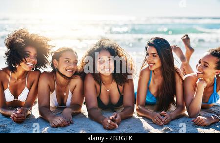 Nichts inspiriert zum Glück wie ein Strandtag mit den besten Freunden. Porträt einer Gruppe glücklicher junger Frauen, die sich am Strand entspannen. Stockfoto