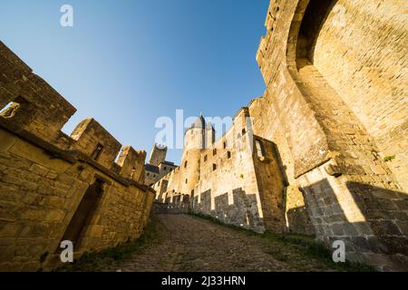 Carcassonne mittelalterliche Zitadelle Haupteingang im Westen und gepflasterter Pfad bei Sonnenuntergang Stockfoto