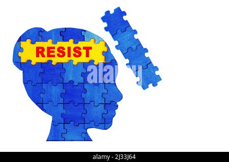 Word RESIST im Inneren eines weiblichen Kopfprofils aus Holz-Puzzleteilen, die blau und gelb lackiert sind. Ukrainischer Widerstand. Stockfoto