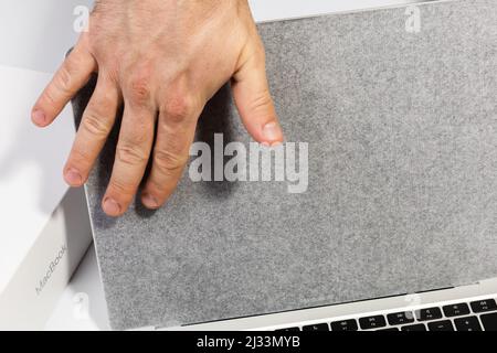 Saratov, Russland - 26. Februar 2022: Berühren Sie Schutzfolie auf dem silbernen Macbook Air 13 Zoll Monitor mit M1 Prozessor Nahaufnahme, weißer Hintergrund Stockfoto