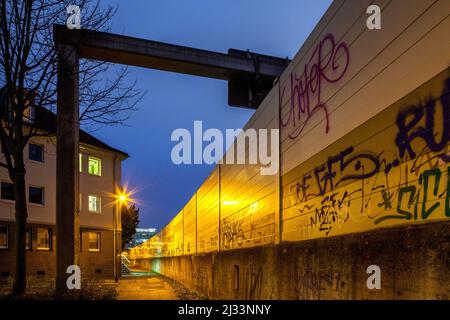 Hohe Lärmschutzwand an der A40 in Essen, Lärmschutz, graffitti, Wohngebiet an der deutschen Autobahn, Stockfoto